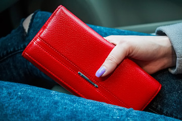 Female hands hold modern red money purse for women