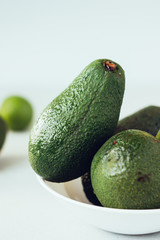 Fresh organic avocado in white ceramic bowl.