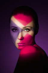 Fashion art portrait of elegant naked young woman with color light on her face