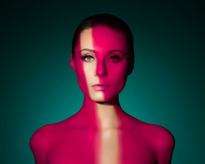 Fashion art portrait of elegant naked young woman with color light on her face