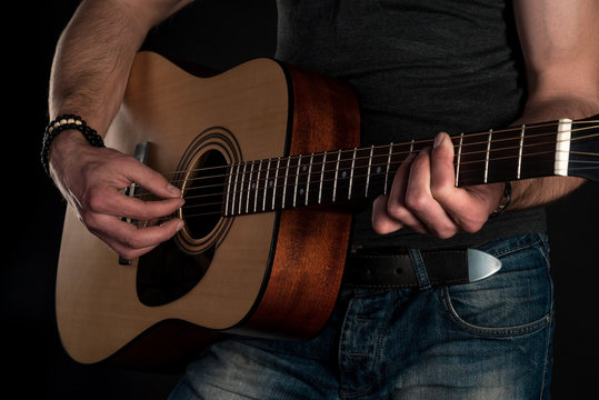 Playing guitar. Acoustic guitar in the hands of the guitarist. Horizontal frame