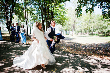 Wedding couple with bridesmaids on blue dresses and best mans having fun at wedding day.