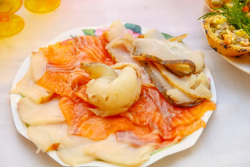 Slices of white and red saltwater fish lying on the plate.