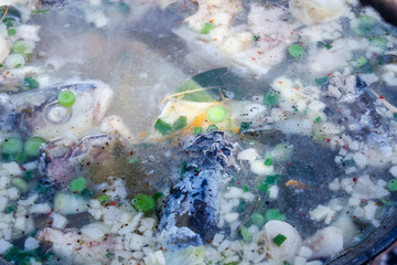 Fototapeta na wymiar Fish soup boils in cauldron, food background