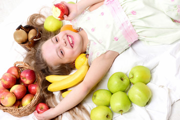 Fototapeta na wymiar cute baby girl laying with colorful fruits in basket