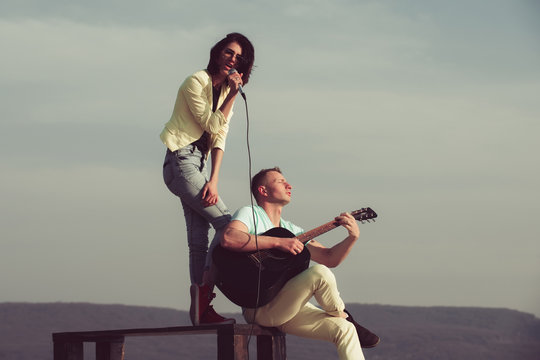music band of man and woman with guitar and microphone