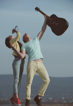 music band of man and woman with guitar and microphone