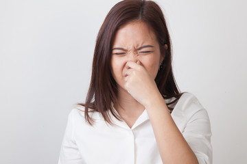 Young Asian woman  holding her nose because of a bad smell. - obrazy, fototapety, plakaty