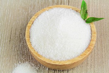 Sugar in wooden bowl isolated on white