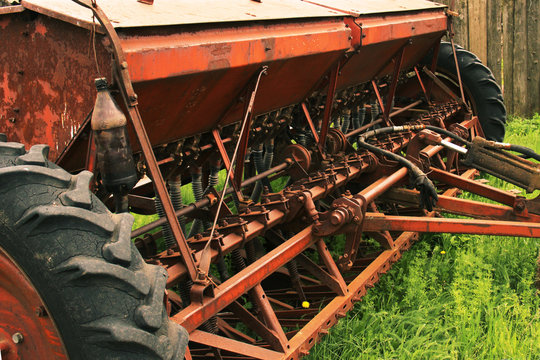 Old grunge Seeding machines Standing on the grass. Decline in agriculture