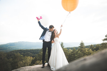 Happy wedding couple kissing and hugging near a high cliff