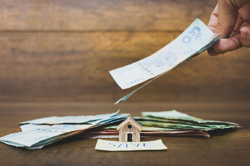 House model and money on wooden background