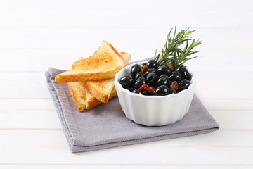 black olives with dried tomatoes and toasts