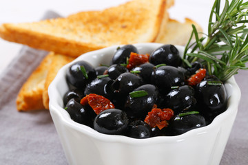 black olives with dried tomatoes and toasts