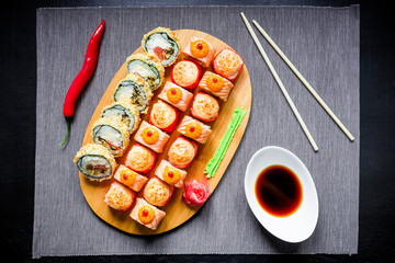 Fototapeta na wymiar Sushi rolls, soy sauce and chopsticks on a grey background. Top view. Flat lay. Japanese food