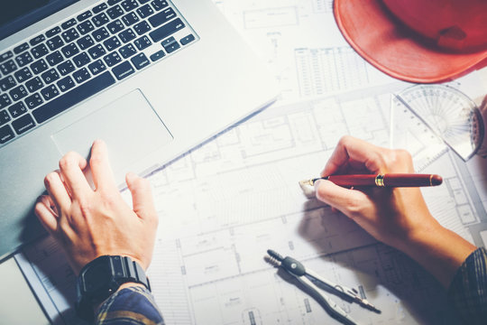 Architect or engineer working in office on blueprint. Architects workplace , blueprints, ruler, helmet and divider. Construction concept. Engineering tools