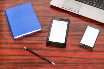 Book, tablet and cellphone on an office desk