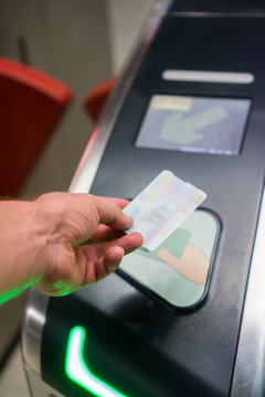 Closeup of man's hand scanning ticket at the metro station entrance machine