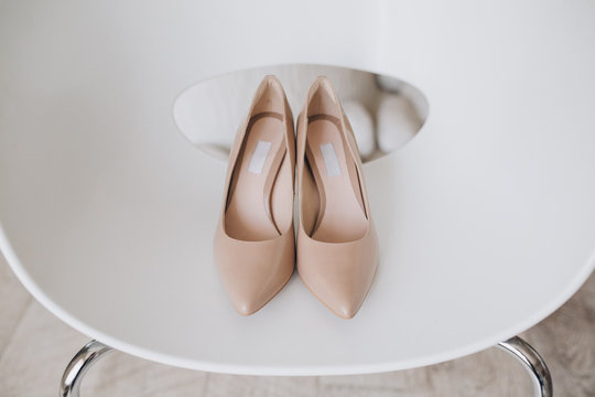 Bridal Wedding Shoes Stand On A White Designer Chair