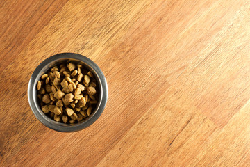 A bowl of dog or cat food on the floor