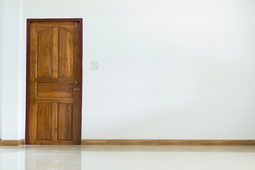 empty room interior with wooden door and white mortar wall