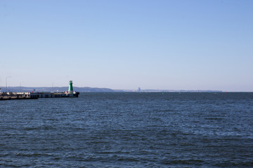 Fototapeta premium One green lighthouses at the entrance to the bay
