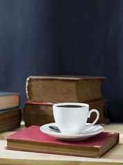 cup of coffee with book on the wood table.