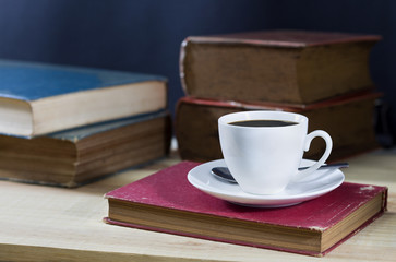 cup of coffee with book on the wood table.
