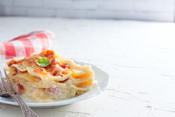A slice of homemade lasagna with ham and cheese, copy space