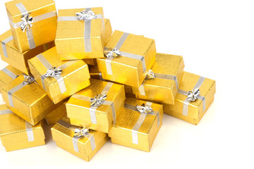 Close up of a pile of gold gifts on white