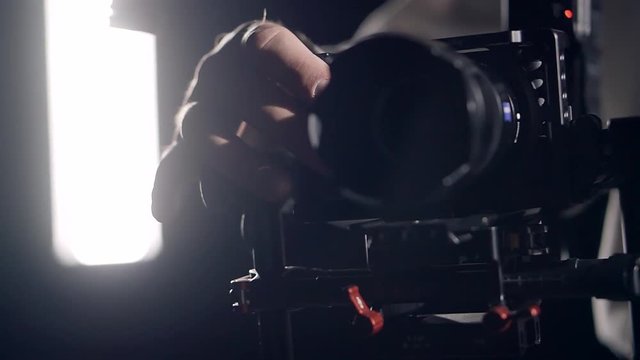 The operator's hand closeup adjusts the camera during shooting video clip