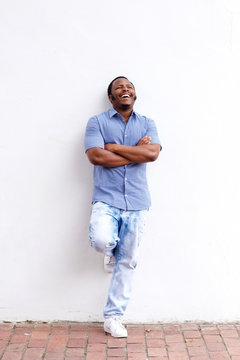 Full Body Happy Black Man Leaning Against Wall And Laughing