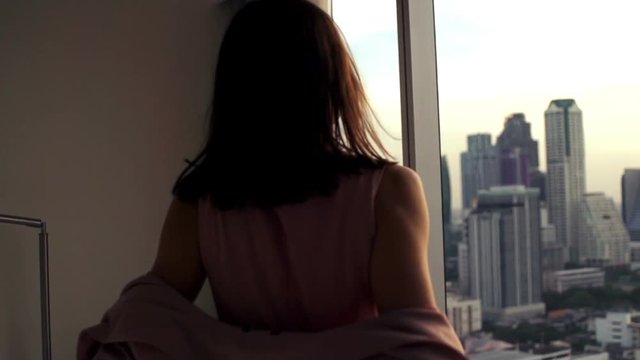 
Elegant, young businesswoman taking off jacket at looking at city, super slow motion 
