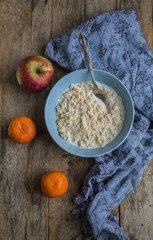 Oatmeal porridge in bowl for breakfast on rustic wooden table