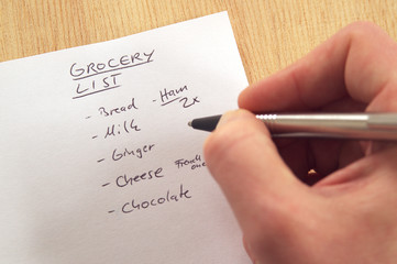 DSC00466_Handwritten_grocery_list_on_white_note_paper_hand_with_pen.jpg