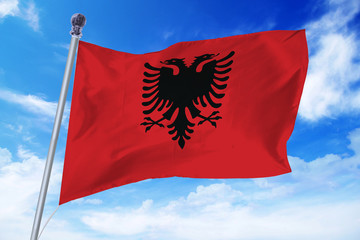 Flag of Albania developing against a clear blue sky