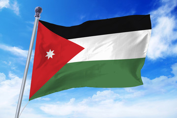 Fototapeta na wymiar Flag of Jordan developing against a clear blue sky