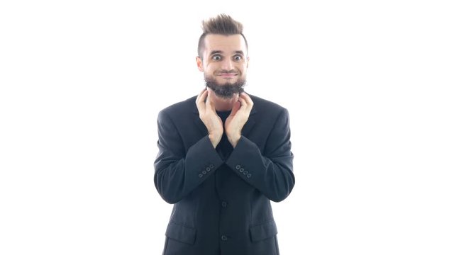 Funny bearded man in suit grimacing, touching his beard and looking at you, studio isolated on white background.