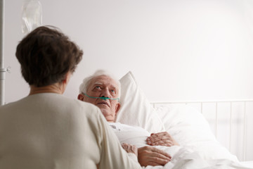 Fototapeta premium Wife sitting by dying husband