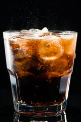 Ice cola with splashing CO bubbles in a glass