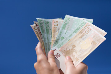 hands wiht euro notes in the blue sky 