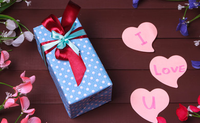 Gift box and red heart with wooden text for I LOVE YOU on wood table background.