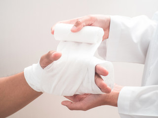 Close-up Of Doctor Hand Wrapping Elastic Bandage To Patient