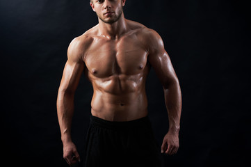 Fototapeta na wymiar Horizontal cropped studio portrait of a confident young athletic man posing shirtless showing off his six-pack on black background copyspace fitness sexy hot masculinity macho fit model sportsman