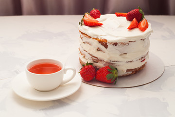 strawberry cake with cup of tea, front view. Homemade cake with strawberry cream and a cup of tea