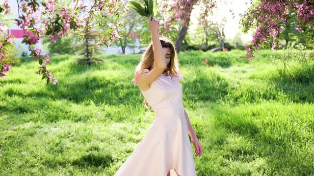 Handsome woman with bouquet of lilies of the valley is getting pleasure. Nature spring concept
