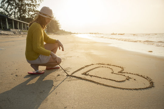 Beautiful Woman Writing Message (heart Symbol) On Sand Beach.