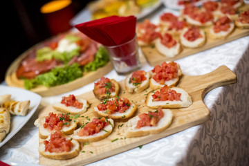 Beautifully decorated catering banquet table with different food snacks and appetizers