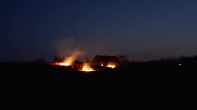 Conflagration on the farmers field at night. Fire inferno rural scene.