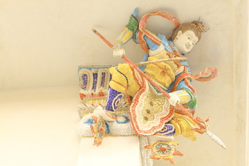 Fototapeta premium Statue of Nezha, Chinese demi god with mosaic or stucco tiles installed under the church roof at Wat Pariwat Temple, Bangkok, Thailand